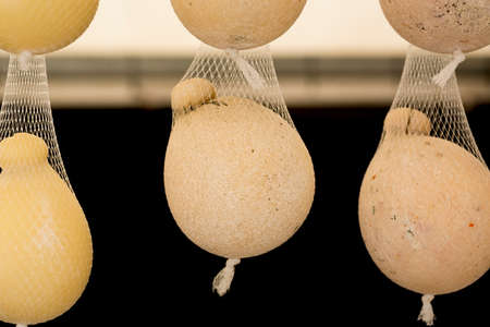 caciocavallo cheese hanging with string for sale at the market