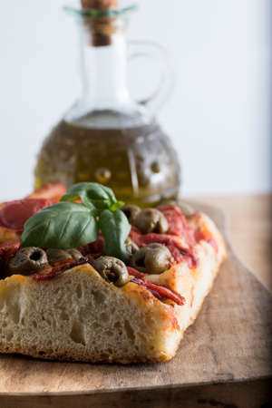 Fresh baked focaccia bread, with olives and tomato pieces.の写真素材