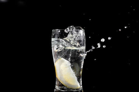 fresh slice of lemon falling in waterの写真素材