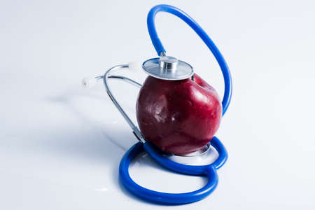Red apple with stethoscope on tableの写真素材