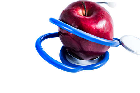 Red apple with stethoscope on tableの写真素材