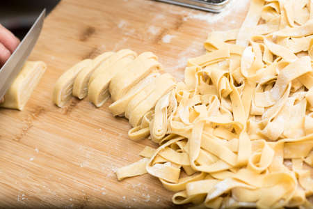 Woman who kneads the homemade pasta to prepare lasagna and tagliatelle.の写真素材