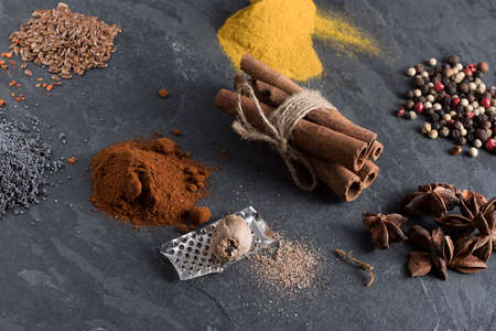 herbs and spices cutlery on dark colored stones.の写真素材