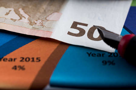 Fifty Euro Banknote in a macro shot, with below chart and sheet accountsの写真素材