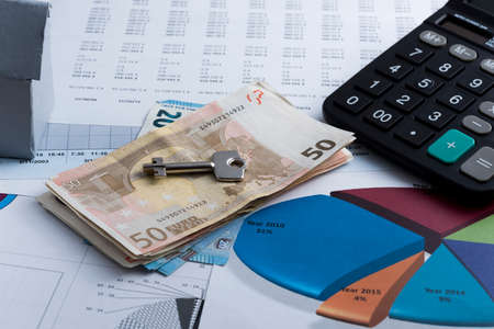 Deal concept for the sale or rental of property, with miniature house and key.の写真素材