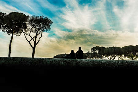 romantic silhouettes by a low wall overlooking Rome. Italy