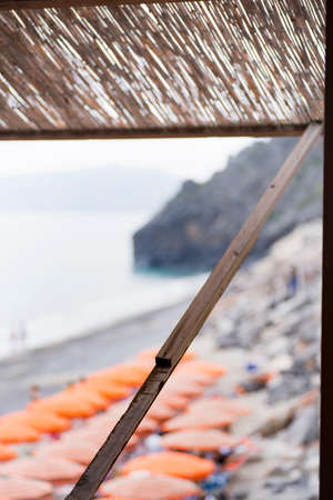 view from a porch of a beach with umbrellas and people all blurryの写真素材