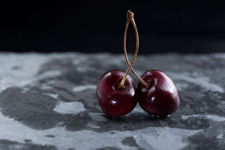 closeup of red cherries on a black stone trayの写真素材