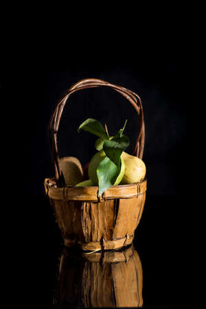 prepared fruit in a basket of vimino vintage, black backgroundの写真素材