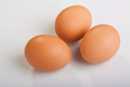 Three brown eggs on white backgroundの写真素材