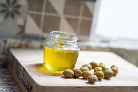 Gourmet olive oil and fresh olives on a wooden tableの写真素材
