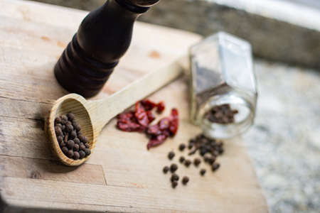 Gourmet ingredients pepper, spices and pepper mill on a wooden tableの写真素材