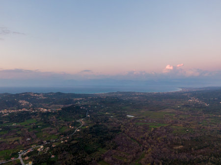 Aerial view of a sprawling landscape at sunset, featuring a blend of land and sea.の写真素材