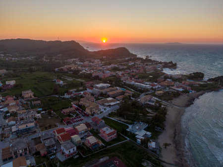 Coastal town at sunset with colorful buildings and tranquil sea.の写真素材