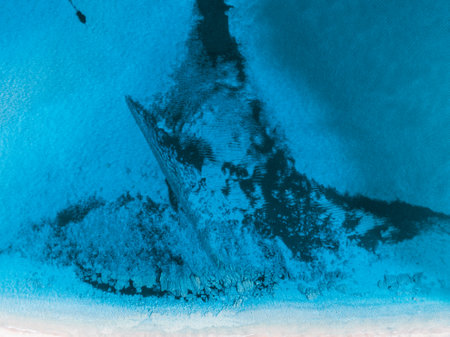 Aerial view of turquoise waters meeting a white sandy beach.