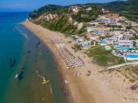 Aerial view of a resort beach with umbrellas and clear water.の写真素材