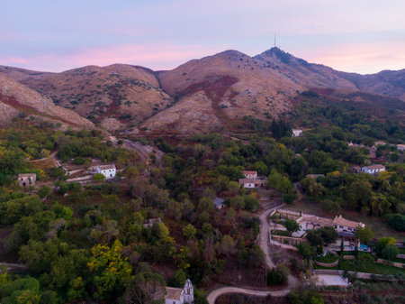 Serene mountain village at dawn, nestled amongst rolling hills.の写真素材