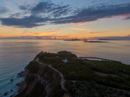 Sunset over coastal cliffs and islands, serene ocean view.の写真素材
