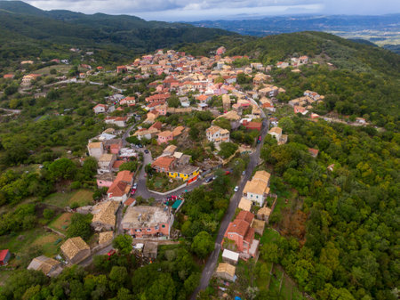 Hilltop village nestled in lush greenery, aerial view.の写真素材