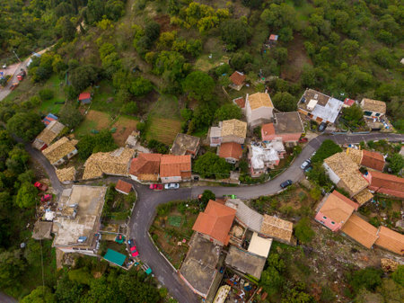Aerial view of a quaint village nestled in a hillside, showcasing traditional architecture and lush greenery.の写真素材