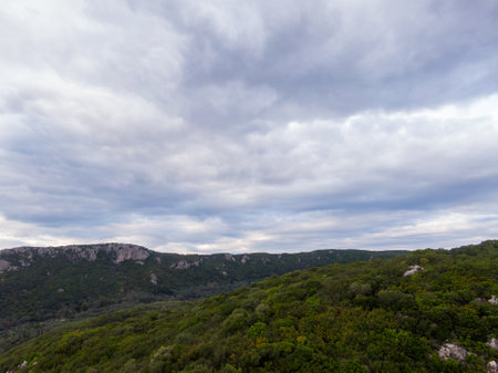 Rolling hills under a cloudy sky, a serene landscape.の写真素材