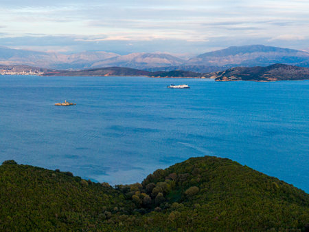Serene coastal view with distant mountains and a passing vessel.