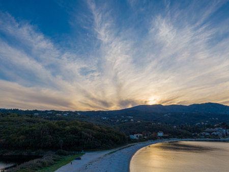 Sunset over coastal beach and mountains. Serene landscape.の写真素材