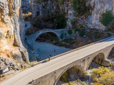 Ancient stone bridge spanning a dry riverbed, nestled in a rocky gorge.の写真素材