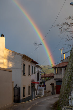 Rainbow arcing over a quaint village street.の写真素材