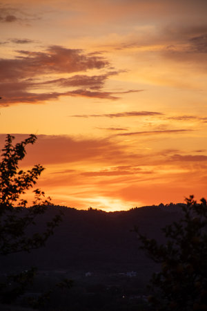 A mesmerizing sunset paints the sky with warm hues, casting a serene glow over the landscape.の写真素材