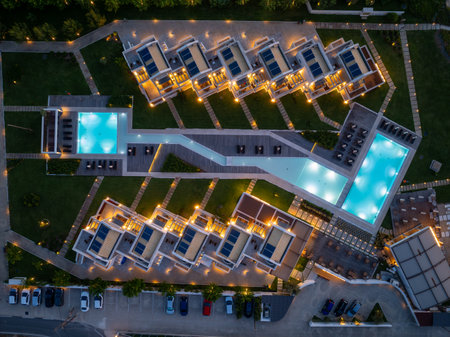 Aerial view showcases a luxury resort at twilight, highlighting pools and solar panel installations.の写真素材