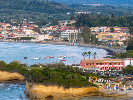 Scenic coastal village on a bay with cliffs, sandy beaches, boats, and lush greenery, a tranquil getawayの写真素材