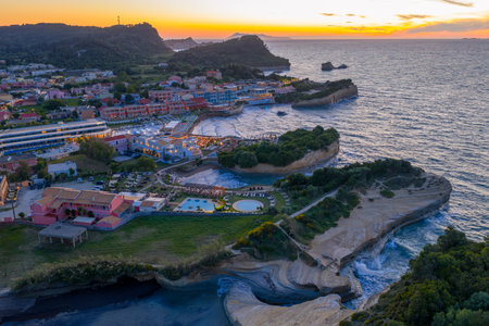 Scenic aerial view of a coastal resort town at sunset, capturing the beauty of land meeting the sea.