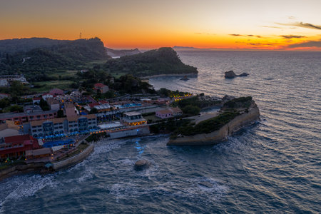Coastal town at sunset: A picturesque seaside village nestled along the rugged coastline under...