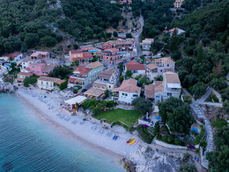 Coastal village nestled by the sea, with colorful buildings and lush green trees covering the hillside.の写真素材