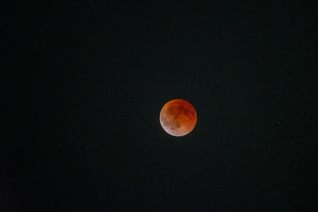 The magnificent Blood Moon glows with an intense red and orange hue during a total lunar eclipse,...