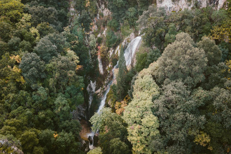 Deep ravine landscape with hidden waterfall in Pagi Corfu Greece showcasing wild Mediterranean vegetation and rocky cliffs aerial drone photographyの写真素材