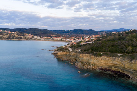 Scenic coastline of Agios Stefanos village with sedimentary cliffs and blue mediterranean sea during...