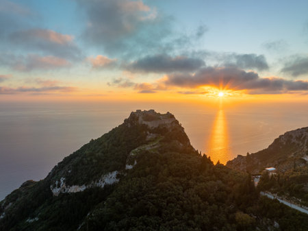 Breathtaking aerial sunset view of Angelokastro castle, an iconic medieval Byzantine fortress on a high rocky cliff overlooking the Ionian Sea, Greece, Europeの写真素材