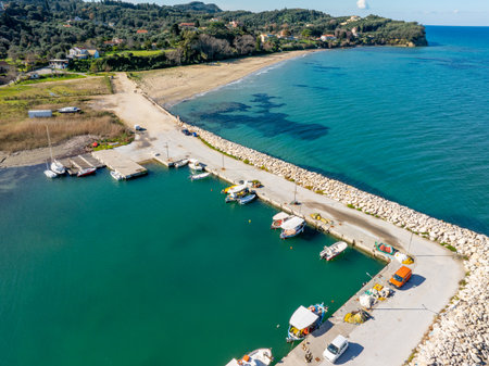 Aerial drone top down view of small traditional fishing harbor in Corfu island with colorful boats...