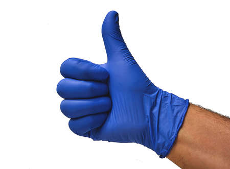 A doctor with a blue glove, makes a fist and raises his thumb, confirming that everything is correct, and that there is no problem, giving the ok.の写真素材