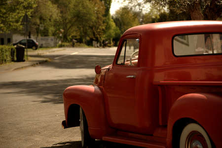 An old red van turns into a streetの写真素材