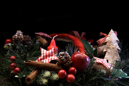 Christmas decoration with candle in front of black background with copyspace.の写真素材