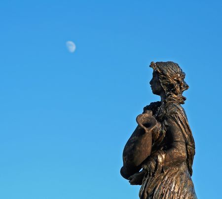 Photo of the women sculpture looking at the moonの写真素材