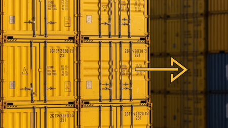 Rows of bright yellow shipping containers are stacked together, creating a repeating pattern. The containers display various markings. An arrow graphic indicates movement or direction. The overall composition suggests a logistics or shipping-related concept, suitable for commercial projects.の素材