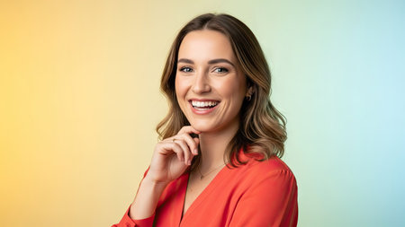 A woman smiles broadly, posing in front of a soft, gradient background. The image presents a medium shot, with focus on the person's face. The lighting is soft and flattering, highlighting her expression. This image might be suitable for various editorial and commercial applications.の素材