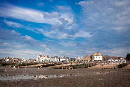 WHITSTABLE, UK - AUGUST 21 2014: People are looking for crabs and clams on the sea bed at low tide in Whitstable. Visitors to can also be seen on the dock side. The harbour was built by the Canterbury and Whitstable Railway Company in 1832.のeditorial素材