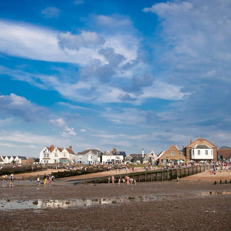 WHITSTABLE, UK - AUGUST 21 2014: People are looking for crabs and clams on the sea bed at low tide in Whitstable. Visitors to can also be seen on the dock side. The harbour was built by the Canterbury and Whitstable Railway Company in 1832.のeditorial素材