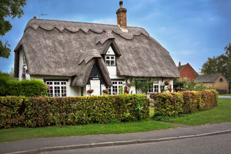COTSWOLDS, UK - OCTOBER 12, 2014: Charming thatched roof house in the Cotswolds English countryside.のeditorial素材