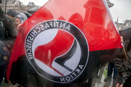 Thatcher Death Party, Trafalgar Square, London, UK.13.04.2013 Protesters congregate on Trafalgar Square, central London whilst participating in a 'Death Party' to celebrate the recent death of Margaret Thatcher. Man hold flag of Antifaのeditorial素材